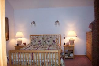 Undisclosed Address Centerville, MA 02632 - Photo 7 of 9 a bed sitting in a bedroom next to a lamp