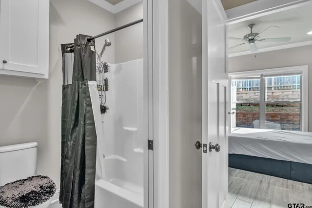 a walk in closet and view of bathroom