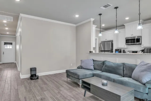 a living room with furniture and a wooden floor