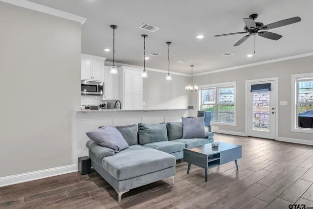 a living room with furniture and a wooden floor