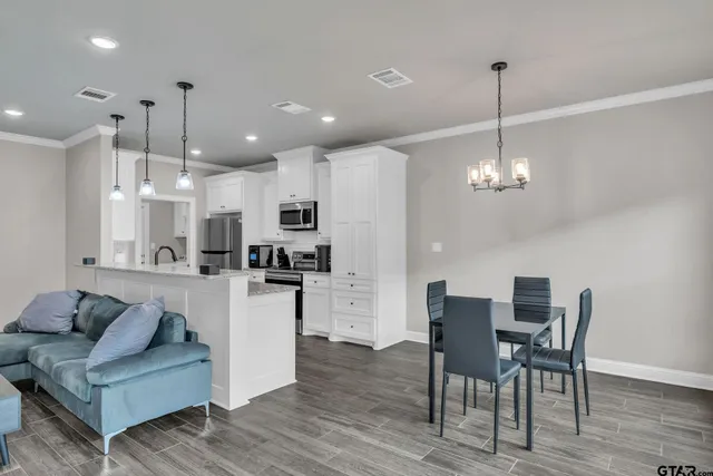 a living room with kitchen island furniture and a chandelier