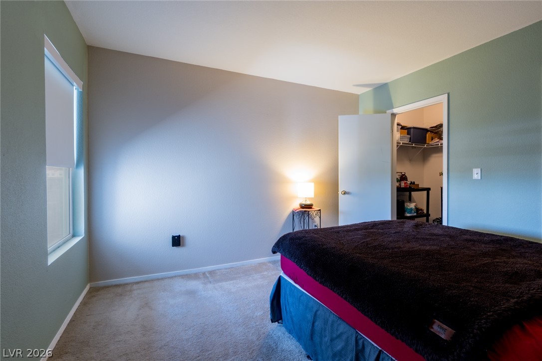 7255 West Sunset Road, Unit 2030 Las Vegas, NV 89113 - Photo 18 of 24 Bedroom featuring a walk in closet and light colored carpet