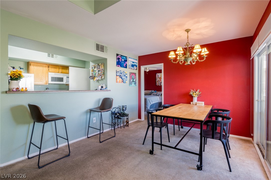 7255 West Sunset Road, Unit 2030 Las Vegas, NV 89113 - Photo 4 of 24 Dining space featuring light colored carpet and a chandelier