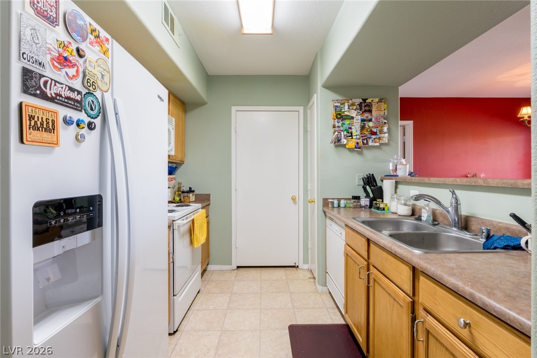7255 West Sunset Road, Unit 2030 Las Vegas, NV 89113 - Photo 5 of 24 Kitchen featuring white appliances, light countertops, and light flooring