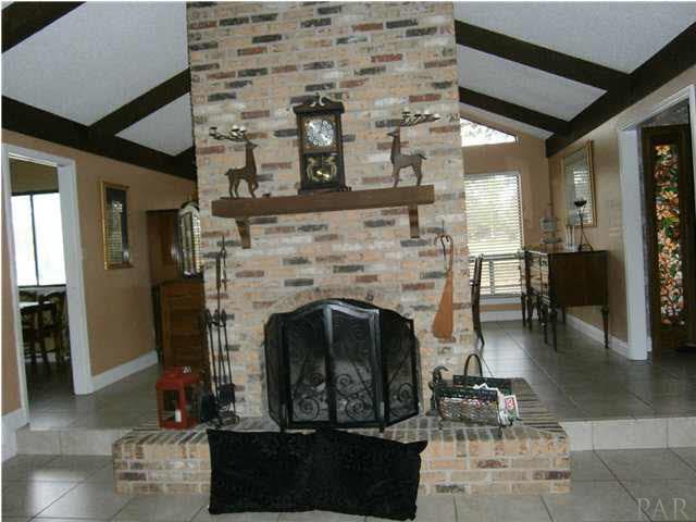 Charming fireplace separating the light, bright dining room from the charming sunken living room