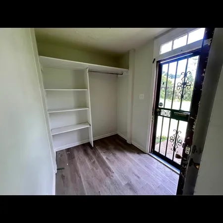 a open area with wooden floor and windows