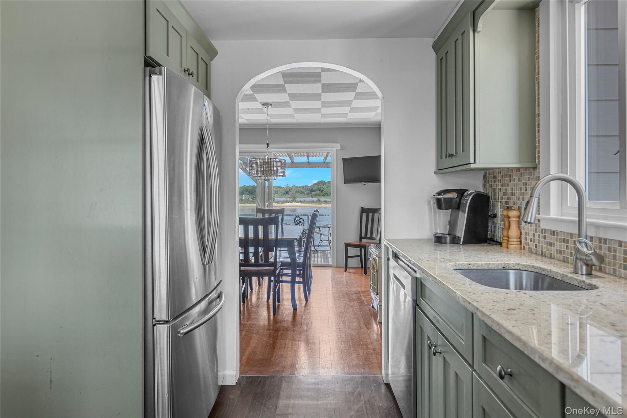 286 Towd Point Road Southampton, NY 11968 - Photo 14 of 35 a kitchen with granite countertop a sink stainless steel appliances a dining table and chairs