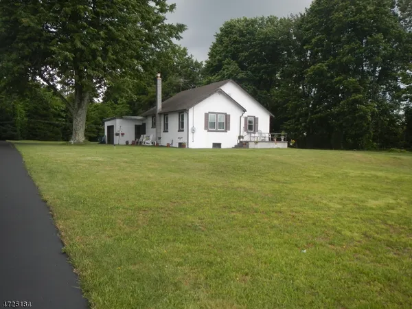 a front door view of a house with a yard and trees