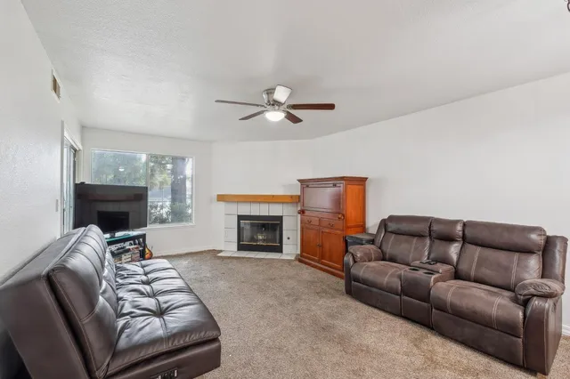 a living room with furniture a fireplace and a flat screen tv