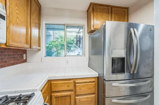 a refrigerator freezer sitting in a kitchen next to a window