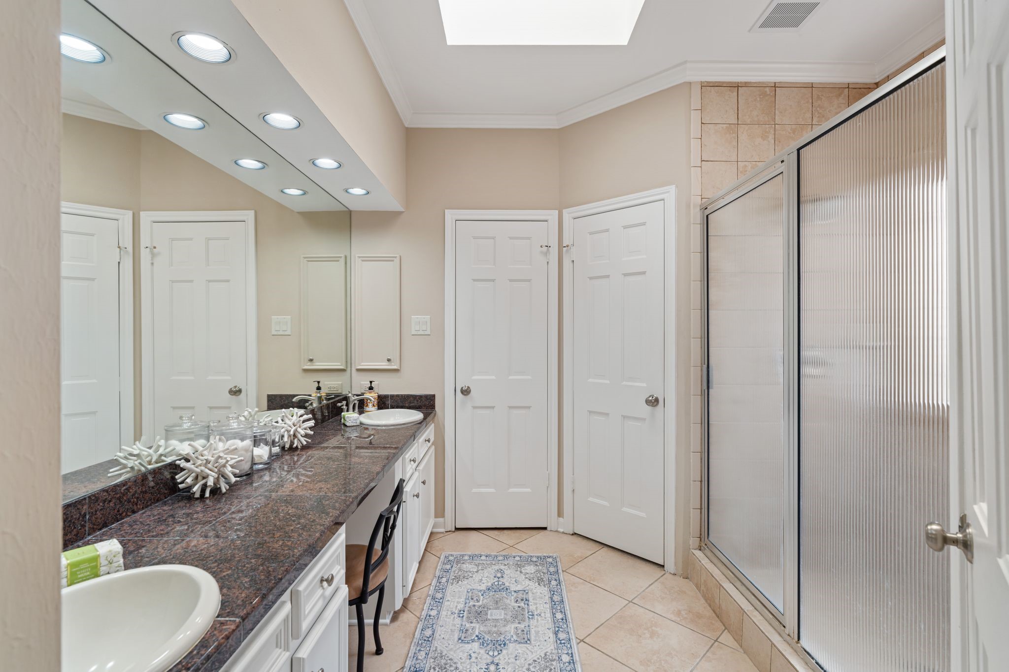 7416 Kelving Street Houston, TX 77030 - Photo 28 of 35 a bathroom with a granite countertop sink a mirror and a shower