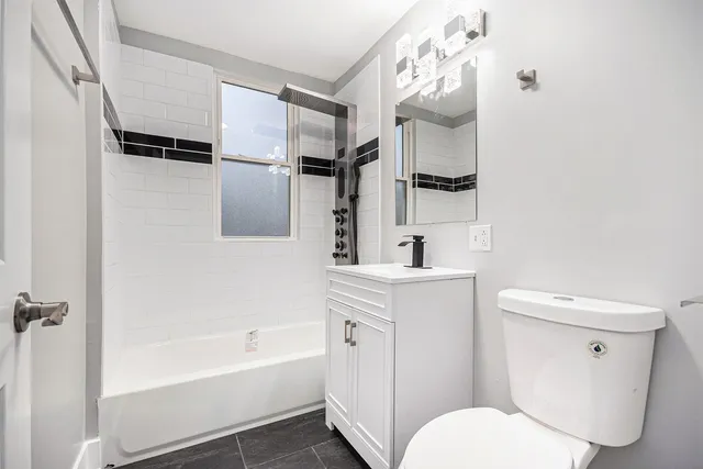 a kitchen with granite countertop white cabinets and a wooden floor