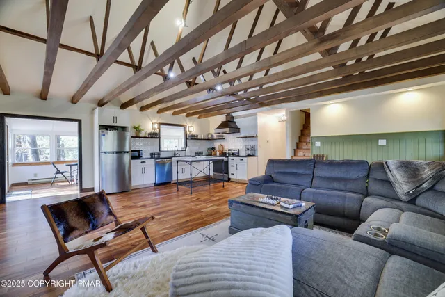 a dining room with wooden floor a chandelier a wooden table and chairs
