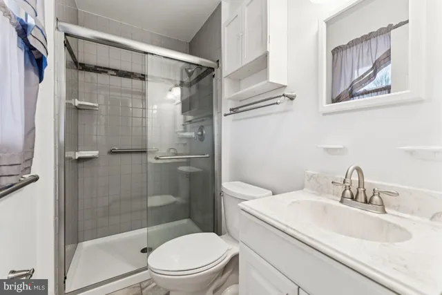 a bathroom with a granite countertop sink toilet and shower