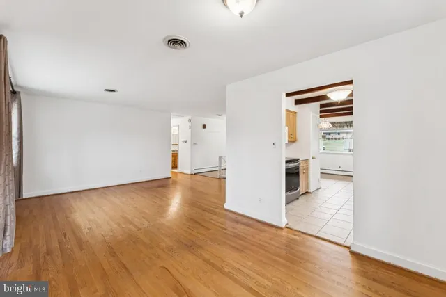 a view of empty room with wooden floor