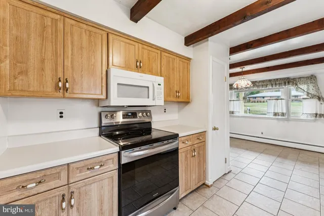 a kitchen with granite countertop a stove a sink and a microwave