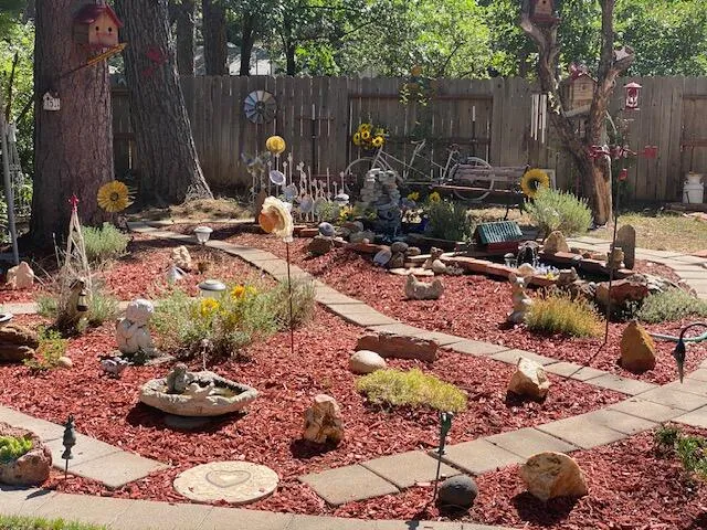 a view of a backyard with plants and chairs