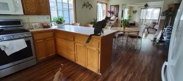 a kitchen with wooden cabinets a sink a stove and wooden floor