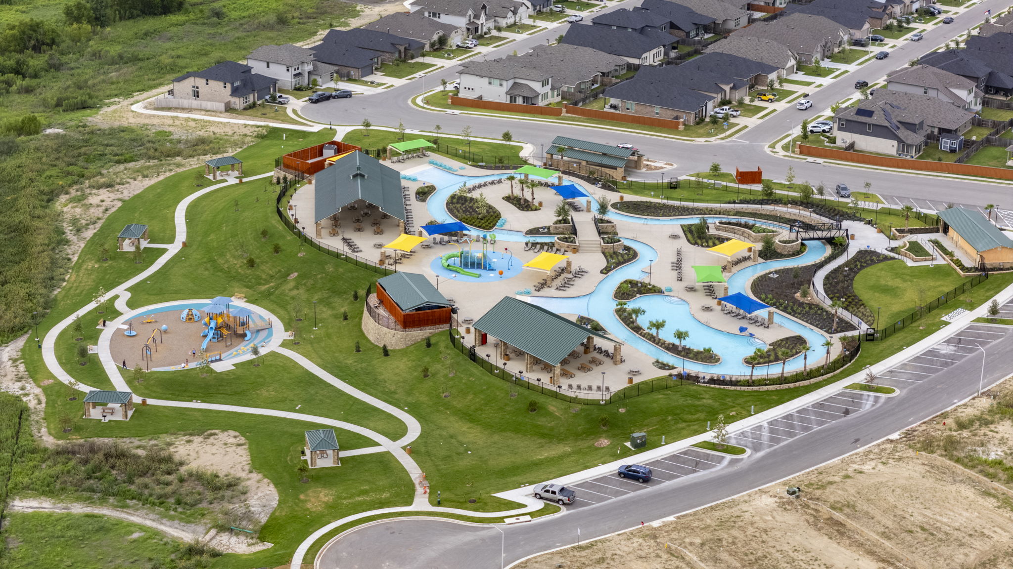 548 Purple Heart Drive Buda, TX 78610 - Photo 30 of 35 An aerial perspective reveals a vibrant community leisure area, complete with an aquatic park and a playground.