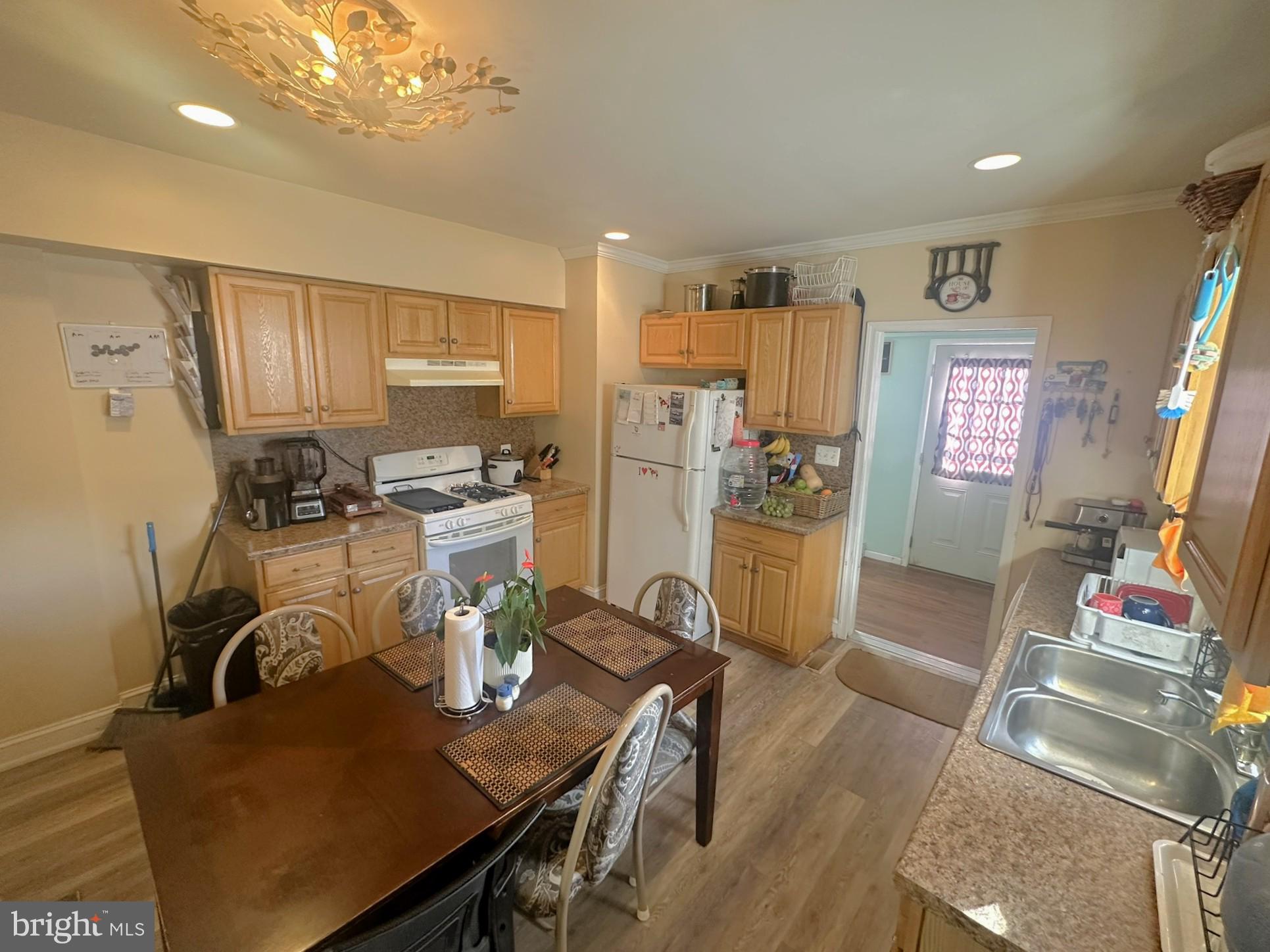 209 Fulton Street Hanover, PA 17331 - Photo 14 of 32 a kitchen with stainless steel appliances granite countertop a refrigerator a stove top oven a dining table and chairs with wooden floor