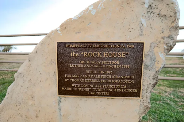 a sign that is sitting on a brick wall