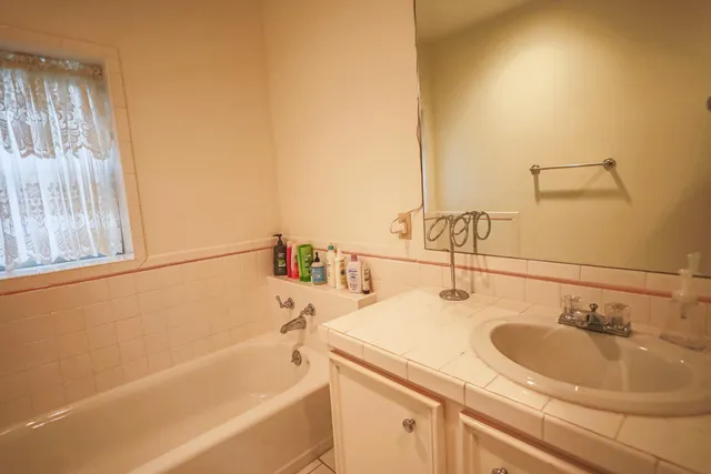 a bedroom with a bed and a double vanity