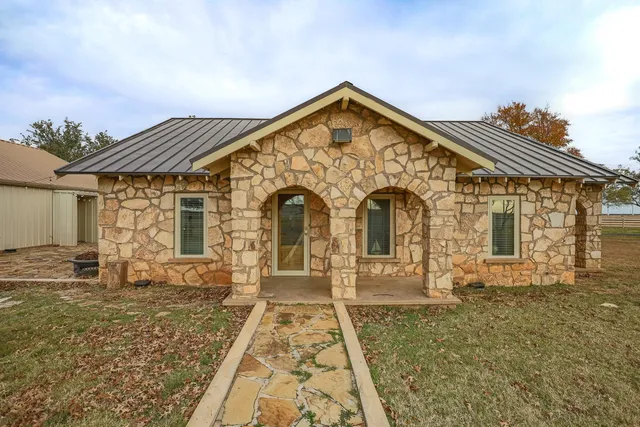 a view of a brick house with a yard