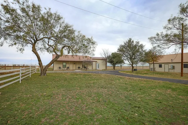 a view of a house with backyard and sitting area