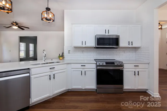 a kitchen with stainless steel appliances granite countertop a stove and a sink