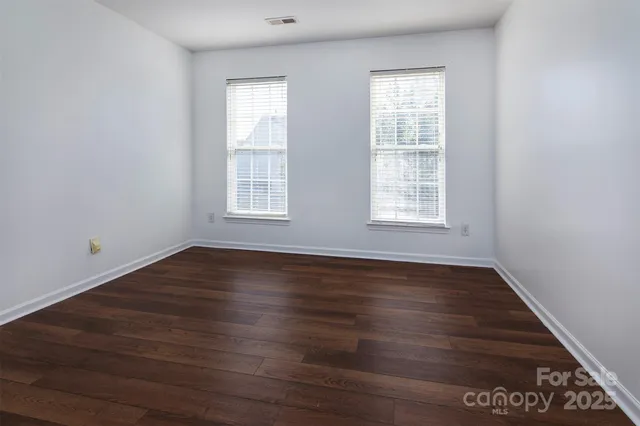 an empty room with wooden floor and window