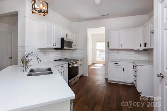 a kitchen with granite countertop a sink cabinets and wooden floor