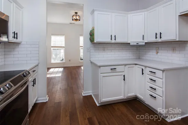 a kitchen with cabinets and wooden floor