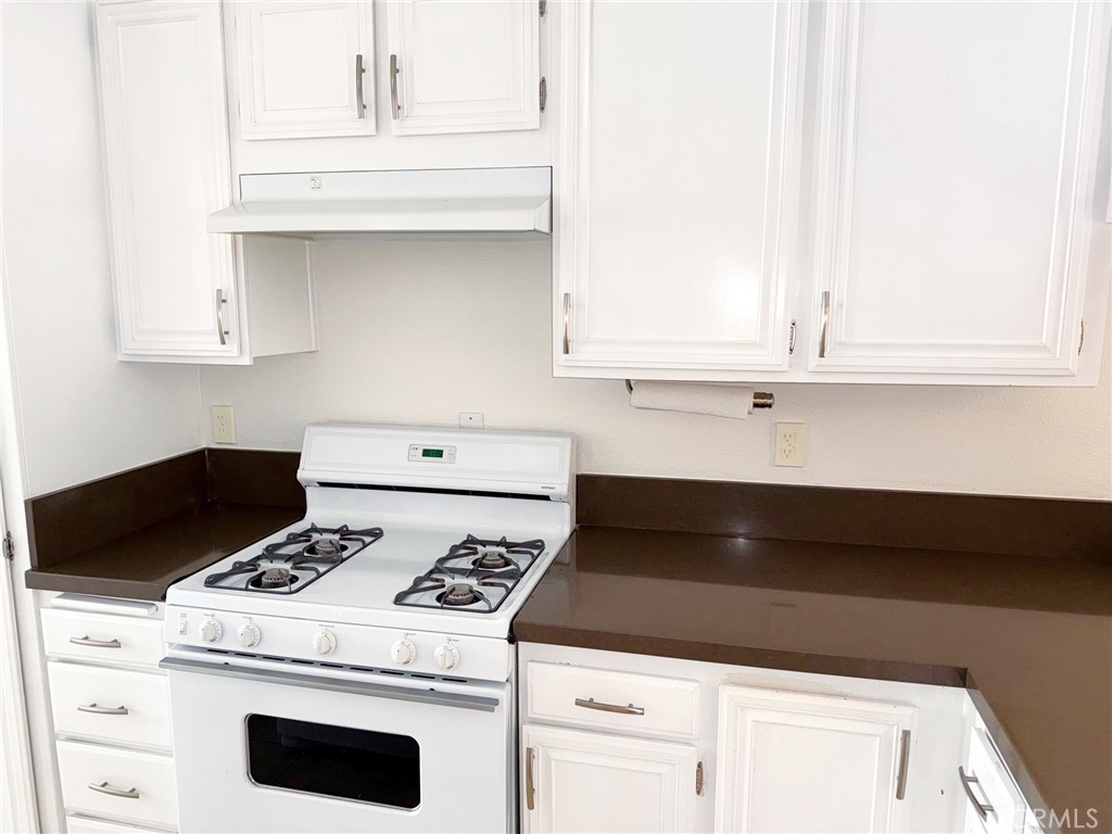 18419 Collins Street, Unit E Tarzana, CA 91356 - Photo 11 of 40 a stove top oven sitting inside of a kitchen