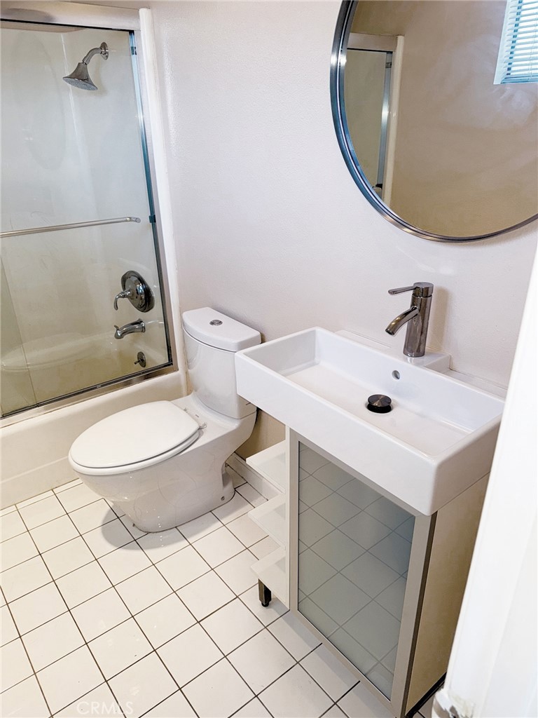 18419 Collins Street, Unit E Tarzana, CA 91356 - Photo 23 of 40 a bathroom with a sink mirror vanity and toilet