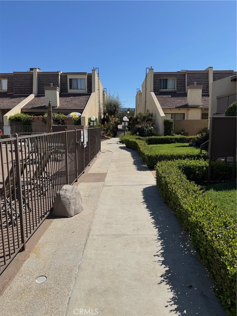 18419 Collins Street, Unit E Tarzana, CA 91356 - Photo 30 of 40 a view of a pathway with a wrought fence