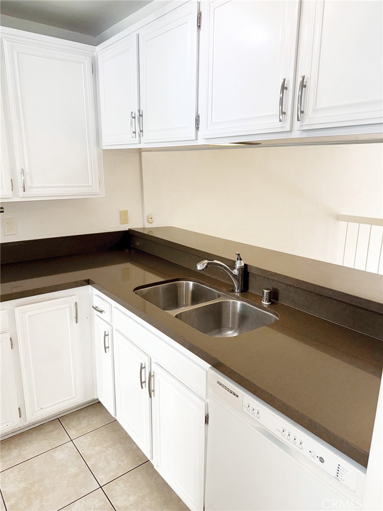 18419 Collins Street, Unit E Tarzana, CA 91356 - Photo 10 of 40 a kitchen with granite countertop white cabinets and a sink