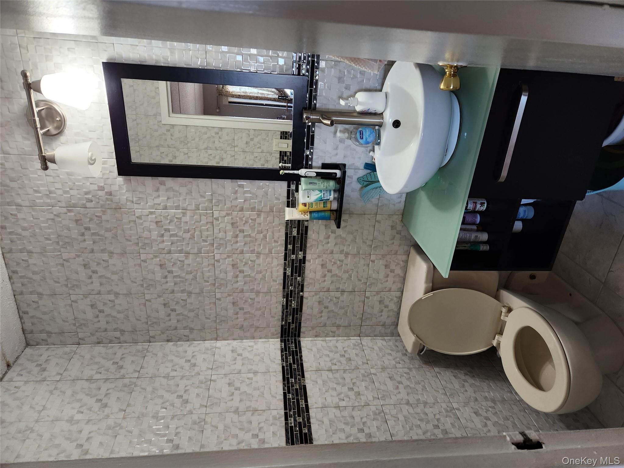 92-29 Queens Boulevard, Unit 11D Queens, NY 11374 - Photo 20 of 22 a bathroom with a toilet a sink and mirror