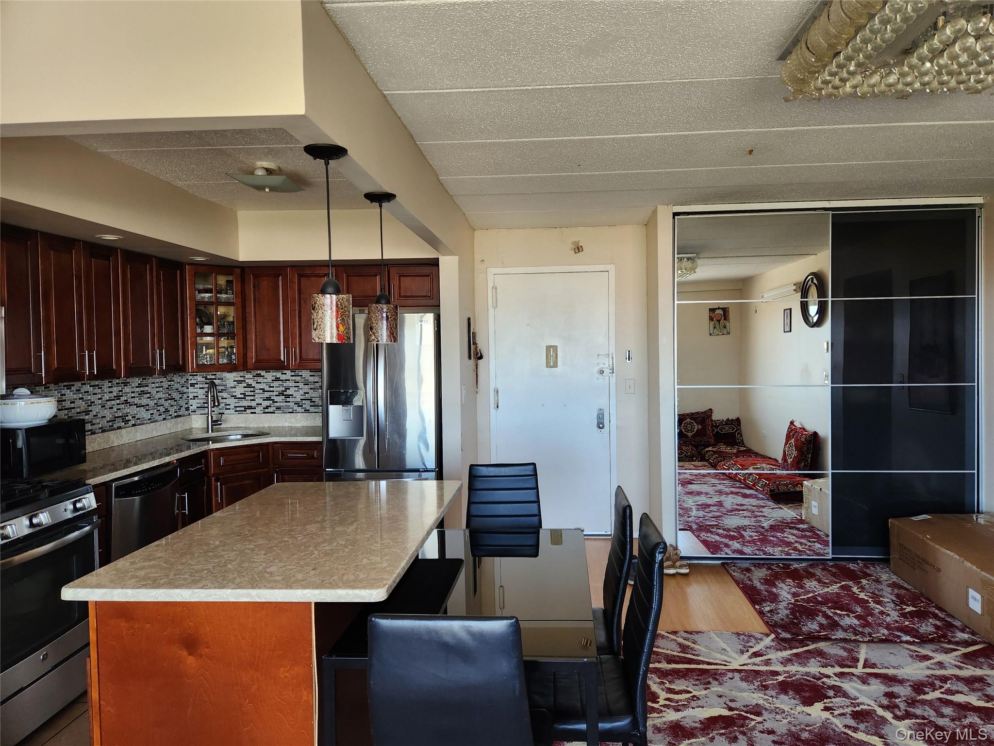 92-29 Queens Boulevard, Unit 11D Queens, NY 11374 - Photo 5 of 22 a kitchen with a table and chairs in it