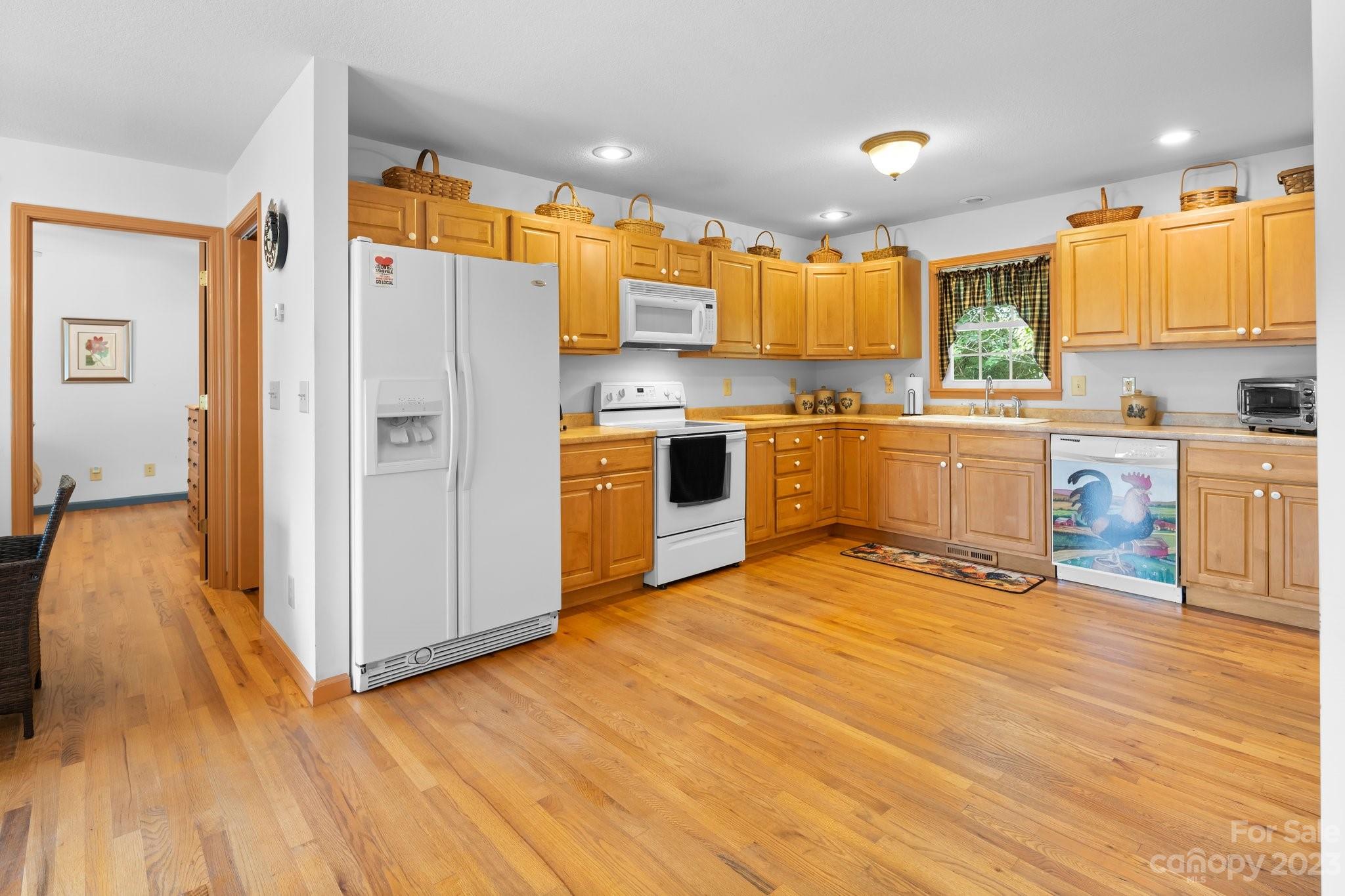 40 Autumn View Drive Hendersonville, NC 28792 - Photo 9 of 48 a kitchen with stainless steel appliances granite countertop a refrigerator a sink dishwasher a stove and white countertops with wooden floor