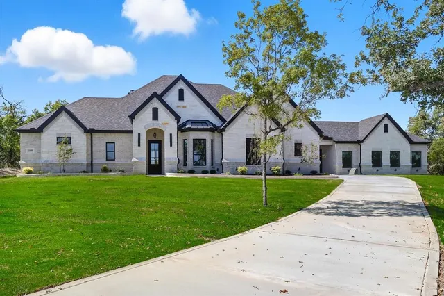 a front view of a house with a garden and yard