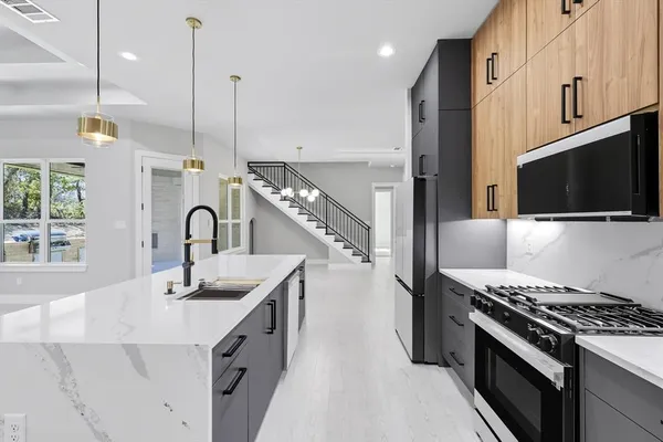 a kitchen with stainless steel appliances granite countertop a sink a stove and a refrigerator