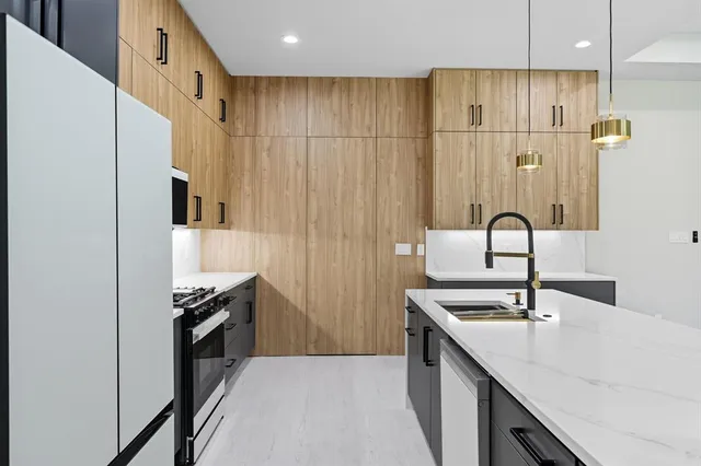 a kitchen with stainless steel appliances a sink and a refrigerator