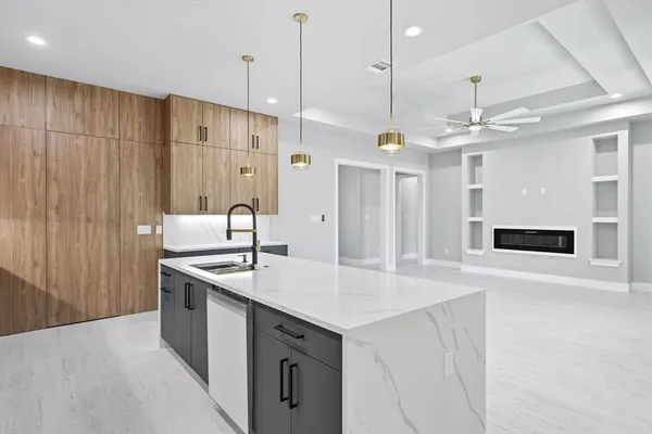 a kitchen with a sink a center island a stove and a refrigerator