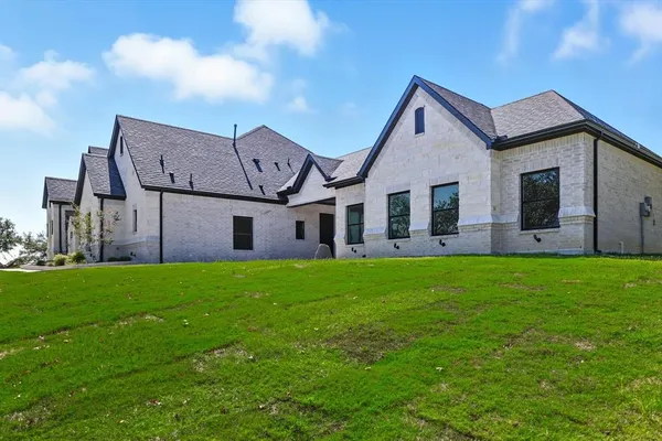 a view of a house with big yard and large tree