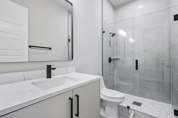 a bathroom with a sink a toilet and shower