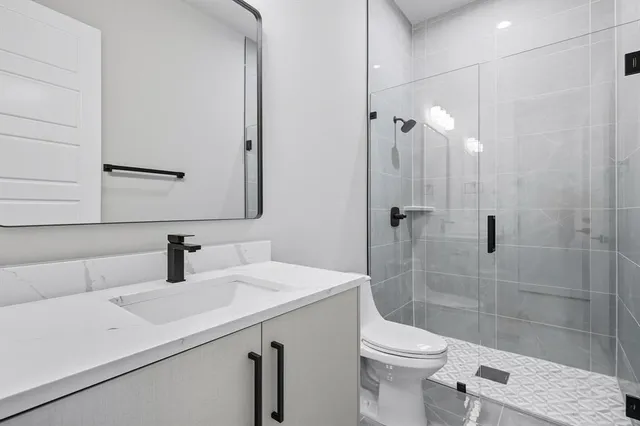 a bathroom with a sink a toilet and shower