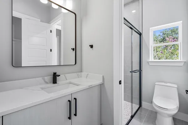 a bathroom with a toilet sink and mirror