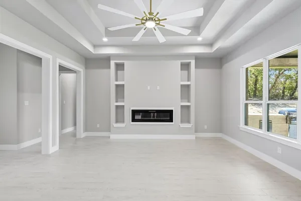 a view of an empty room with a fireplace and a window