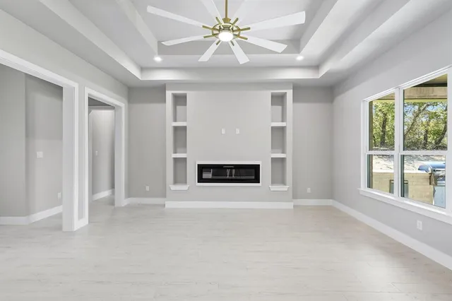 a view of an empty room with a fireplace and a window