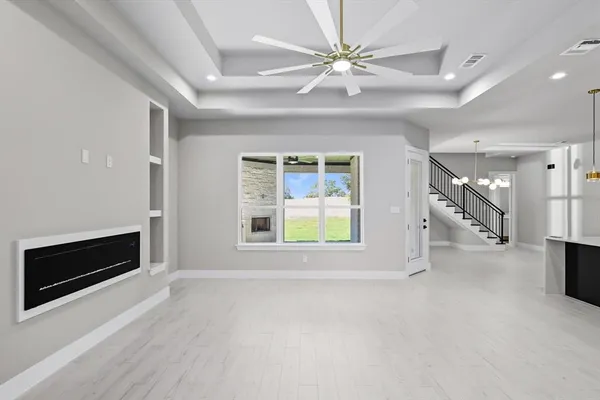 a view of an empty room with a fireplace and a window